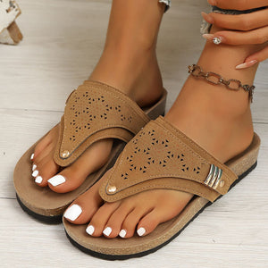 Brown hollow-out toe-post sandals with cork-style sole and adjustable ankle strap.