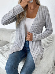Light gray ribbed knit cardigan with a drape front and pockets, worn open over a white tank top.