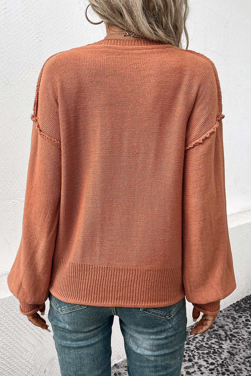 Raglan sleeve knit sweater in pumpkin acrylic with raw edge details and ribbed hem.