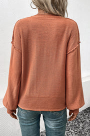 Raglan sleeve knit sweater in pumpkin acrylic with raw edge details and ribbed hem.