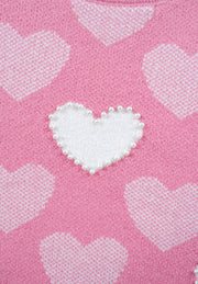 Pink knit sweater with white intarsia hearts and pearl-embellished heart detail.