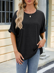 Relaxed fit black crew neck t-shirt with rolled short sleeves, styled with jeans.