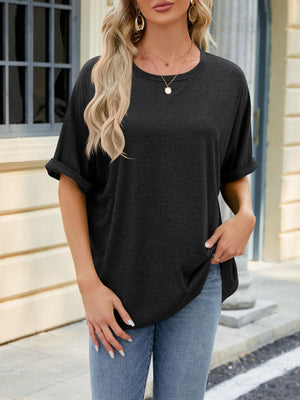 Relaxed fit black crew neck t-shirt with rolled short sleeves, styled with jeans.
