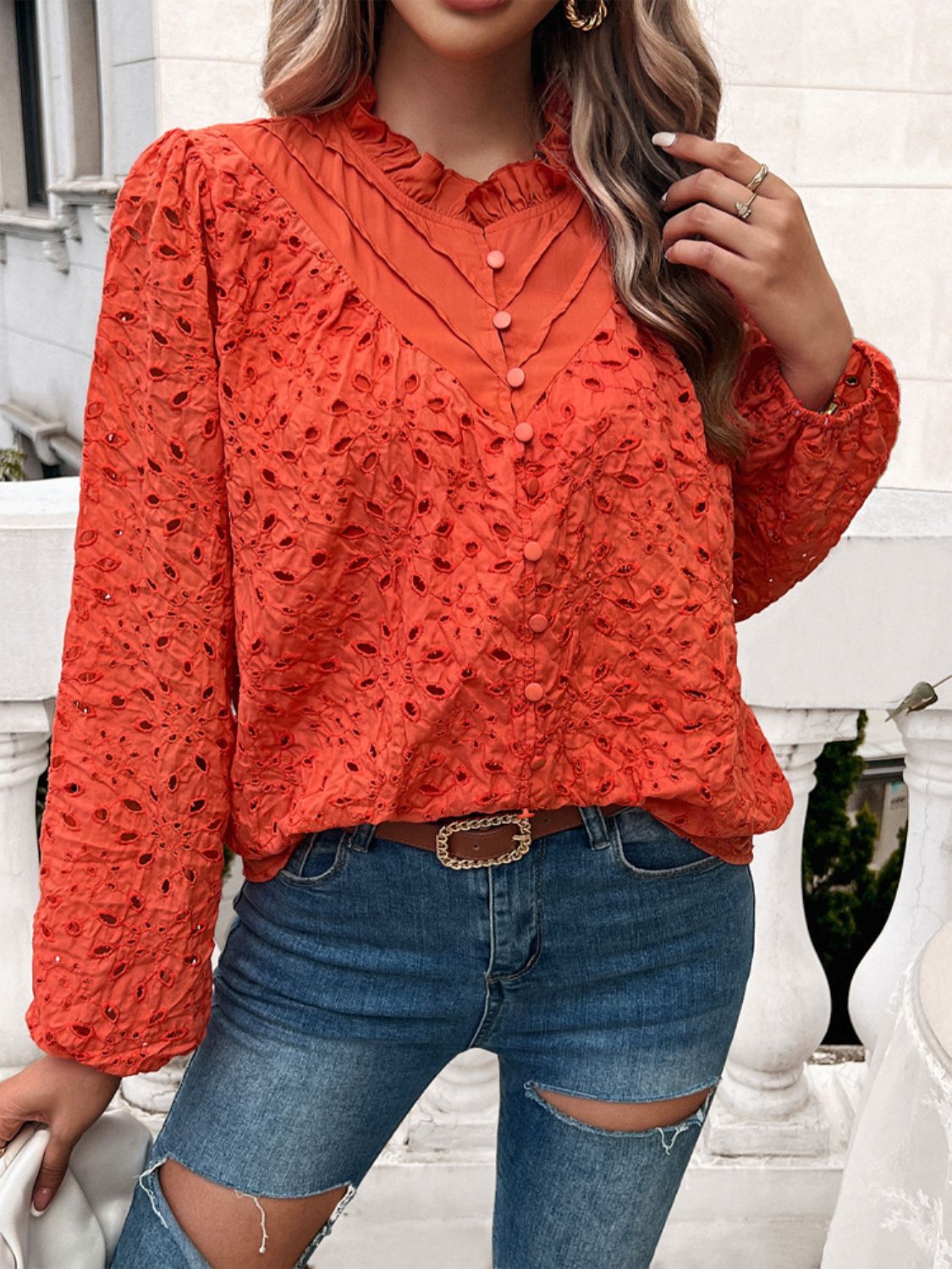 Orange-red eyelet embroidered blouse with ruffle collar and button front.