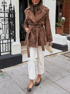Belted double-breasted dark brown trench coat with cuffed sleeves and a tie belt.