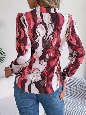 Women's abstract swirl print silk blouse with button front and long sleeves.