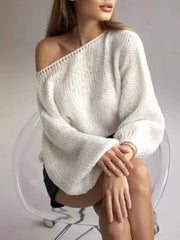 Cream oversized knit sweater with balloon sleeves and boat neck, styled off-shoulder.