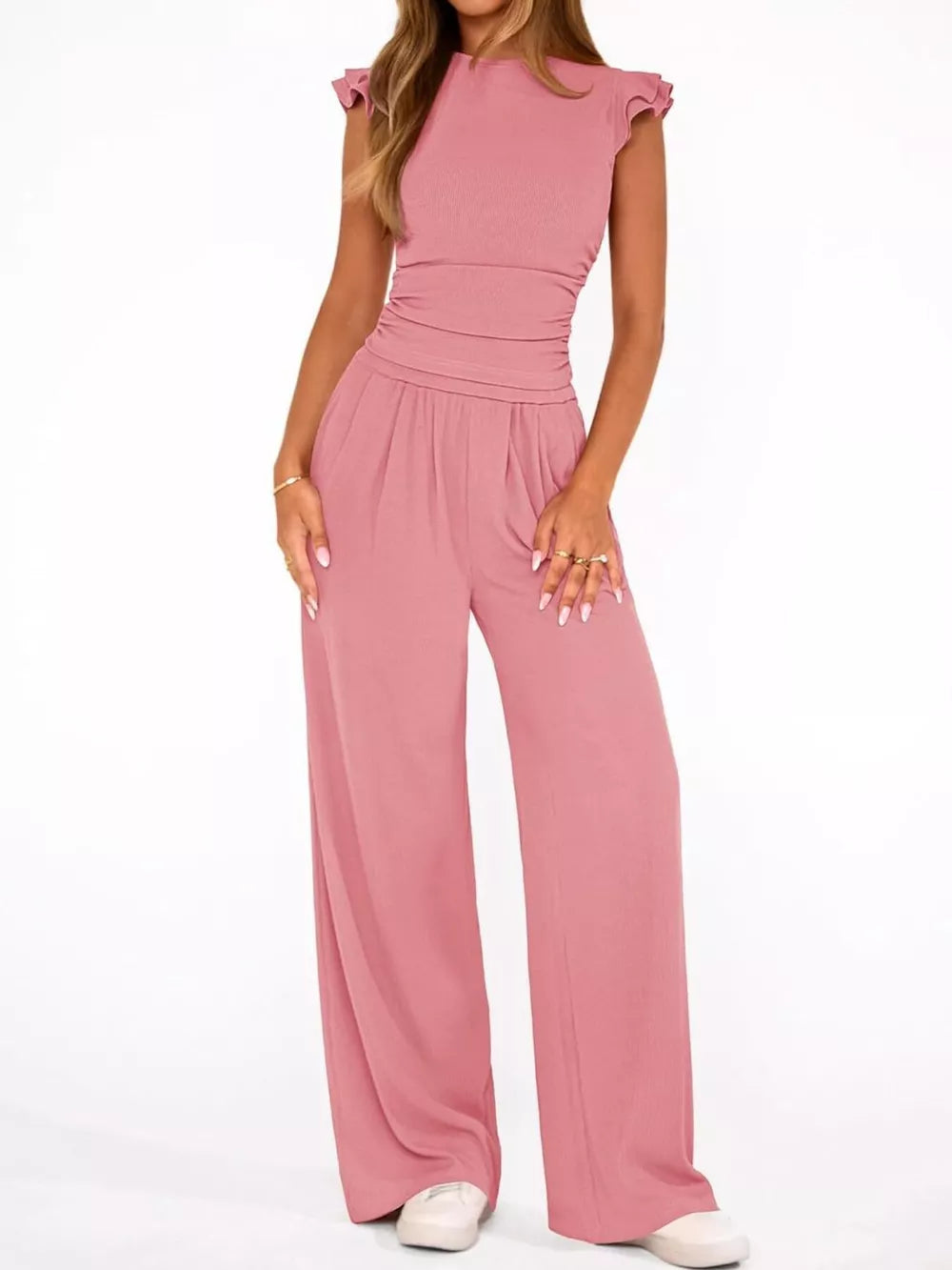 Pink ruffled cap sleeve maternity jumpsuit with ruched waist and wide legs.
