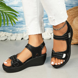 Black textured wedge sandals with adjustable straps and contrast stitching.