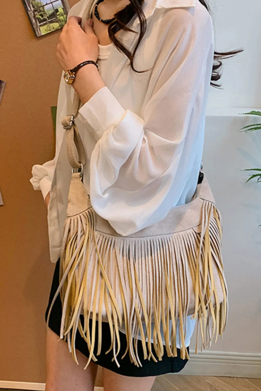 Bohemian suede crescent crossbody bag with fringe detail in caramel.