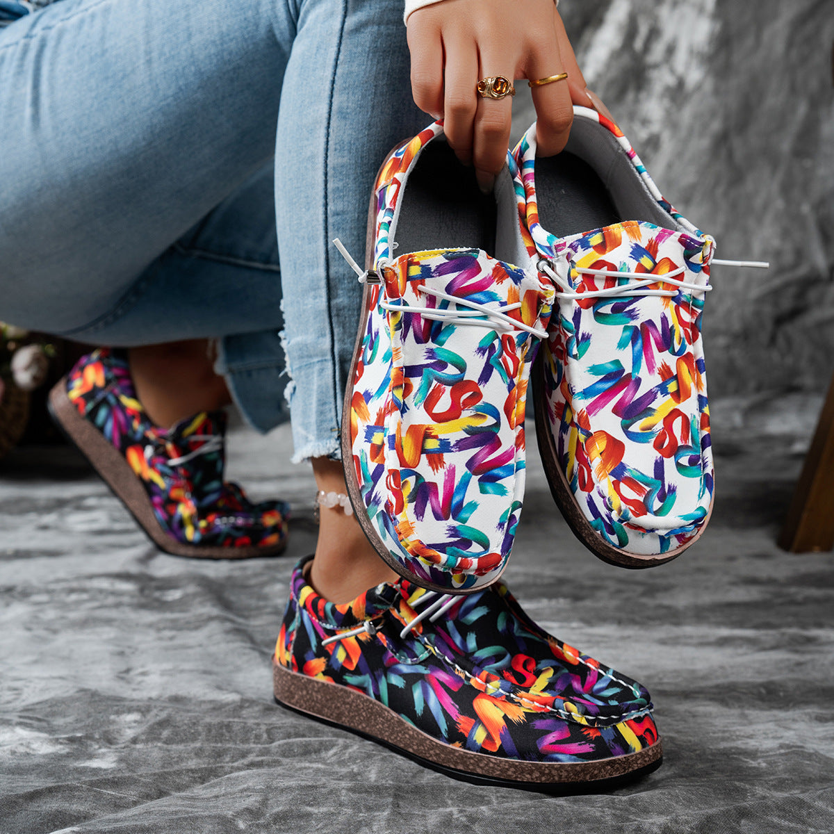 Printed casual slip-on loafers with abstract brushstroke pattern in white and black.