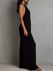 Black halter neck wide leg romper with deep side cutouts and flowing legs.