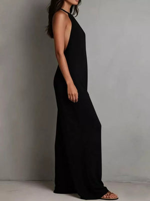 Black halter neck wide leg romper with deep side cutouts and flowing legs.