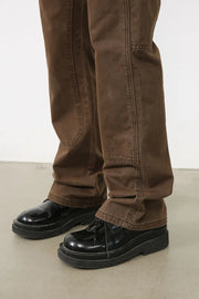 Utility-inspired carpenter trousers in coffee brown with reinforced knees and contrast stitching.