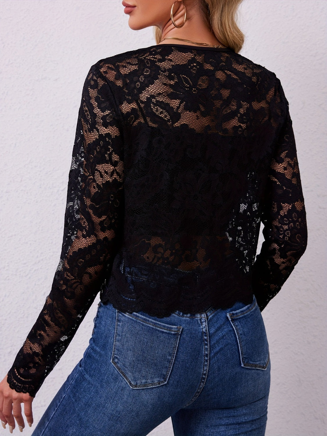 Black lace cropped open-front jacket with scalloped hem and long sleeves.