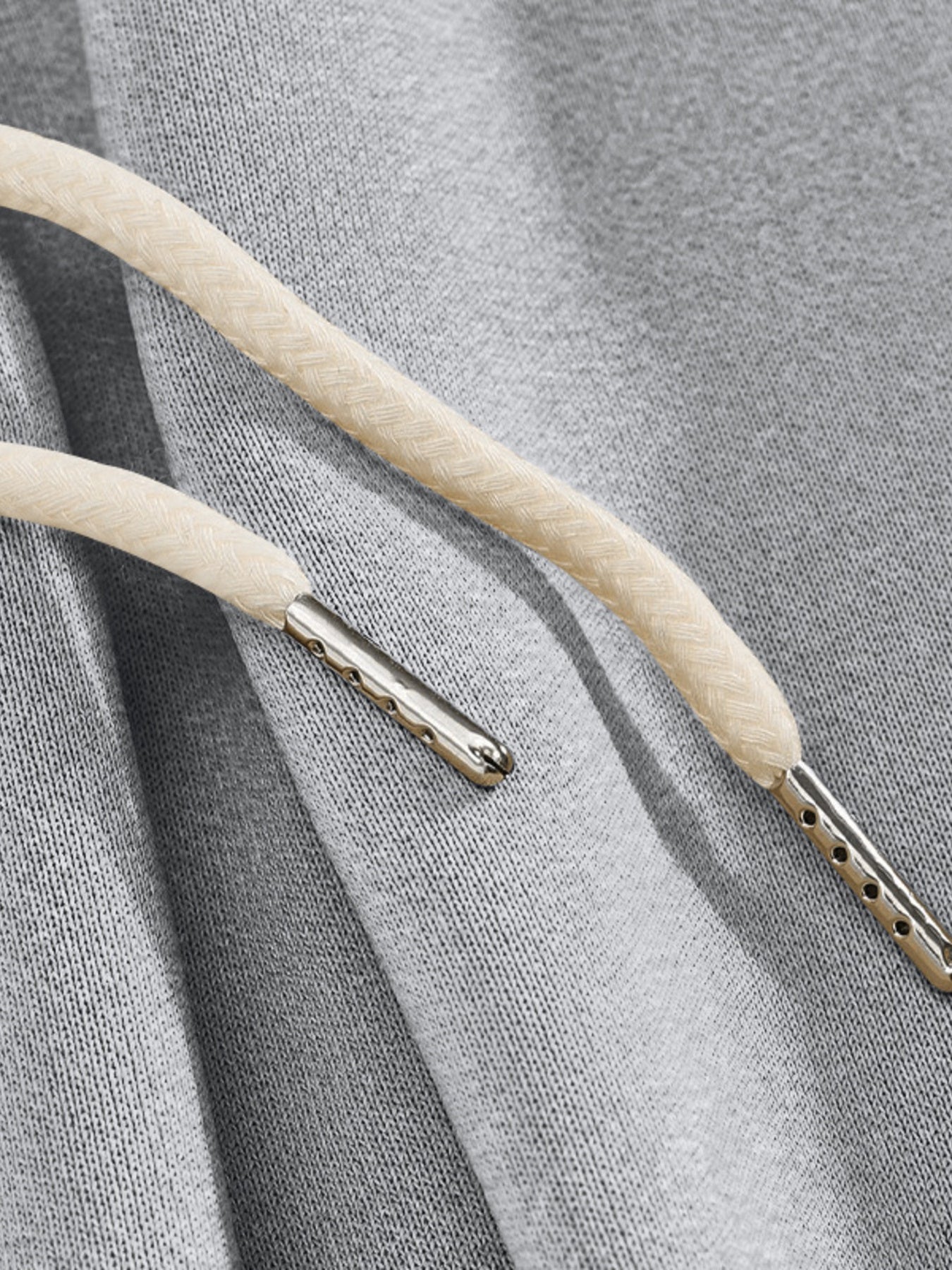 Light gray men's sweatpants with drawstring detail and metal aglets.