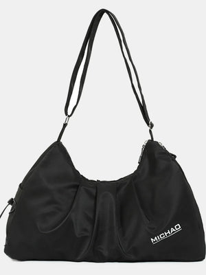 Black gathered pleat crossbody bag with adjustable strap and logo detail.