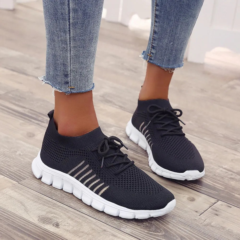 Black knit runner sneakers with ribbed detail and white soles.