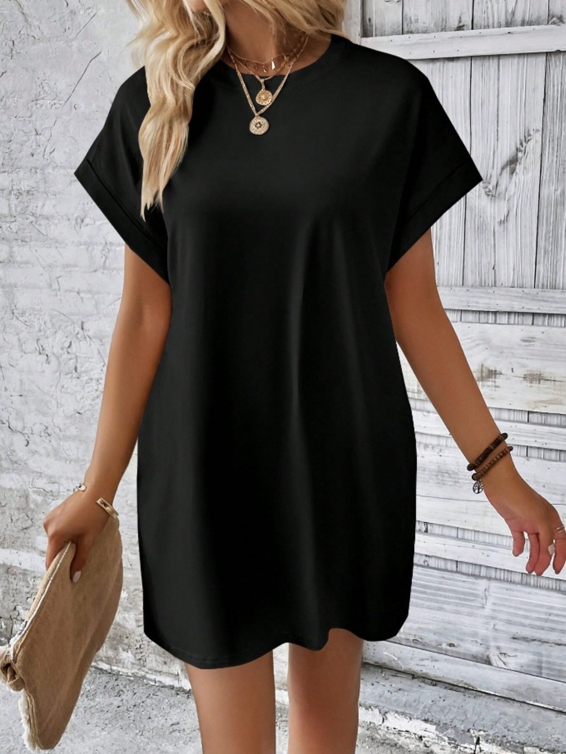 Black relaxed tee dress with cuffed sleeves and crew neck, styled casually.