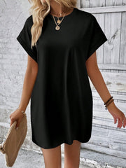 Black relaxed tee dress with cuffed sleeves and crew neck, styled casually.