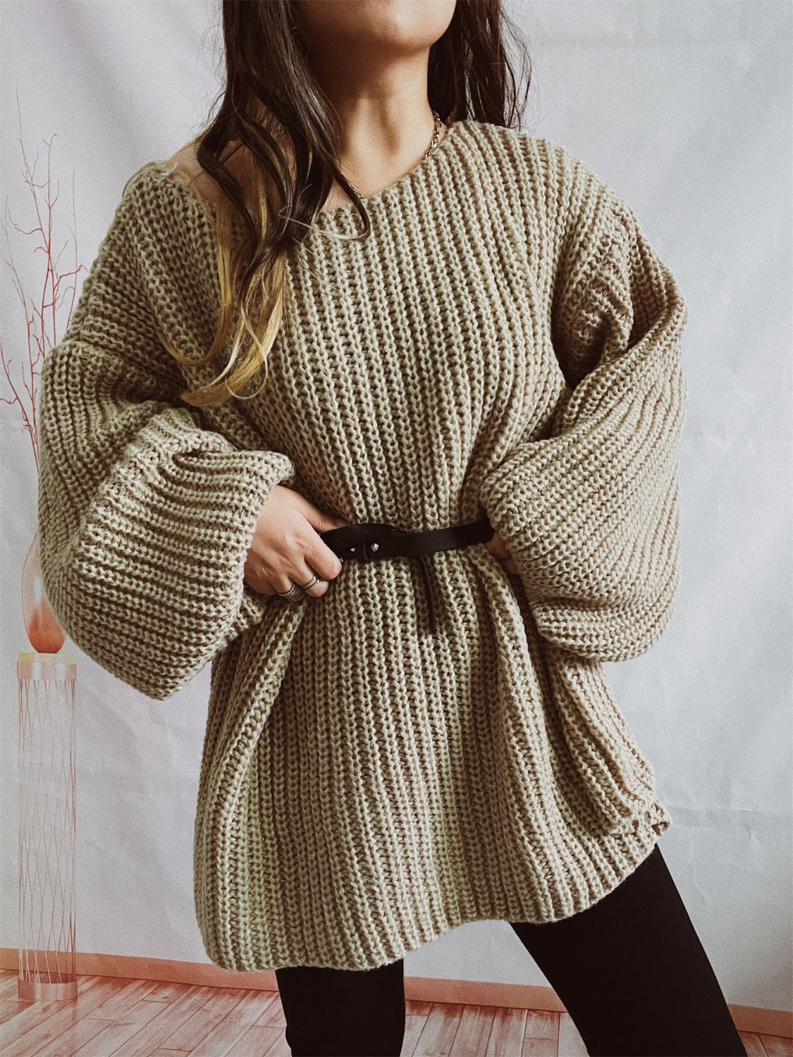 Beige oversized ribbed knit sweater with belted waist and balloon sleeves.