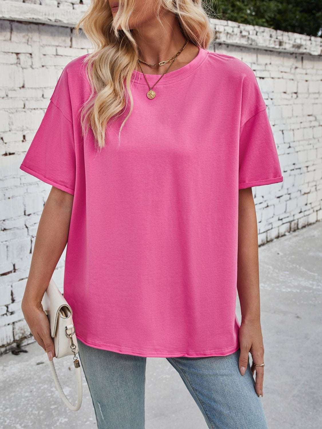 Oversized hot pink cotton tee with seam details and rolled sleeves.