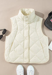 Ivory quilted stand collar vest with snap closure and side pockets.