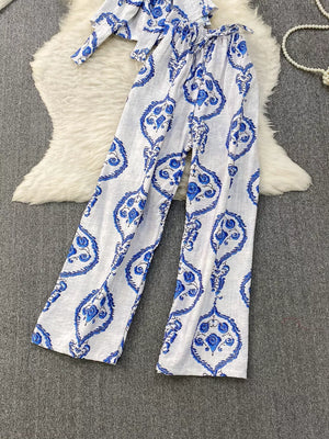 Blue and white tropical print two-piece set with wide-leg pants and belted detail.