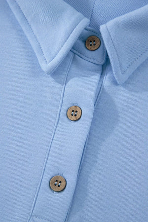 Light blue sleeveless polo shirt with wooden buttons and collar detail