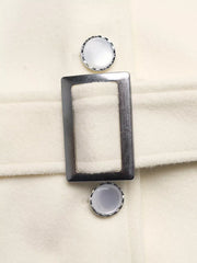 Belted button-up trench coat in beige with silver buckle and decorative buttons.