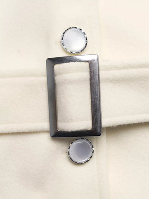 Belted button-up trench coat in beige with silver buckle and decorative buttons.