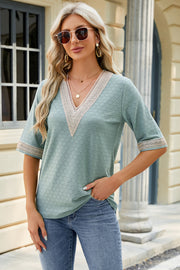 Light green textured V-neck top with lace trim on neckline and sleeves.