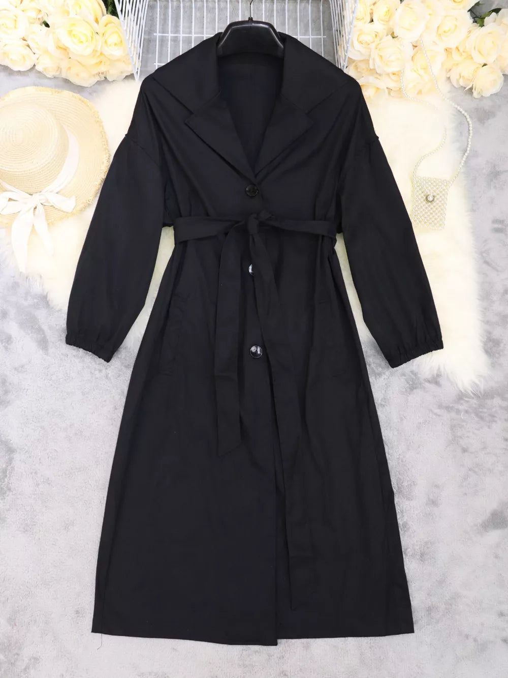 Black midi dress with lapel collar, tie waist, and cuffed sleeves.