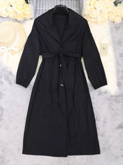Black midi dress with lapel collar, tie waist, and cuffed sleeves.