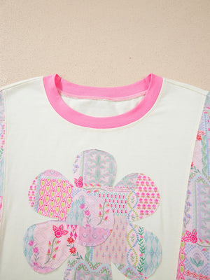 Maternity t-shirt with floral patchwork applique and pink crew neck.