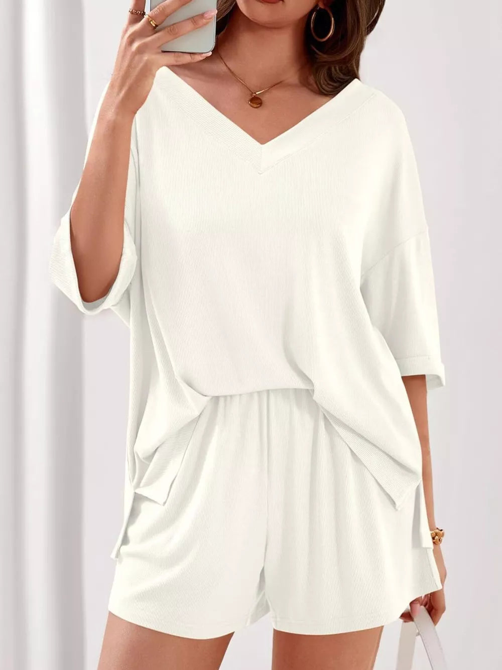 Ivory V-neck lounge set with relaxed fit top and drawstring shorts.