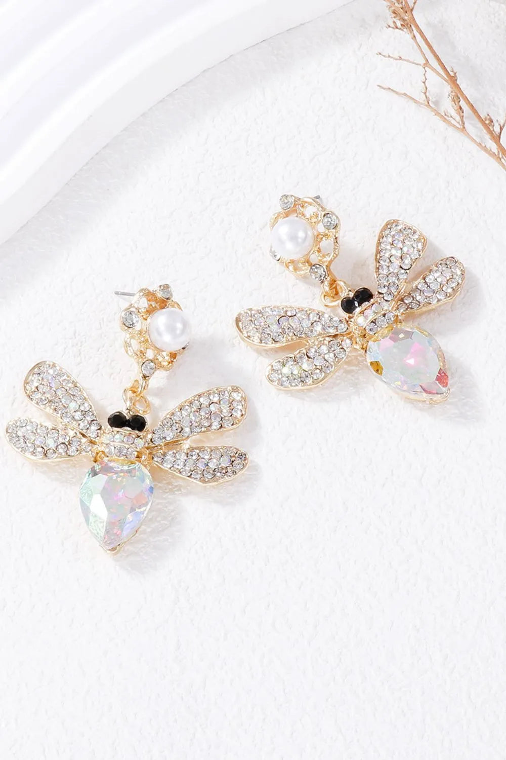 Gold chandelier earrings with jeweled dragonfly design and pearl accents.