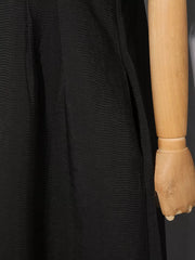 Black midi dress with textured fabric and a side slit detail.