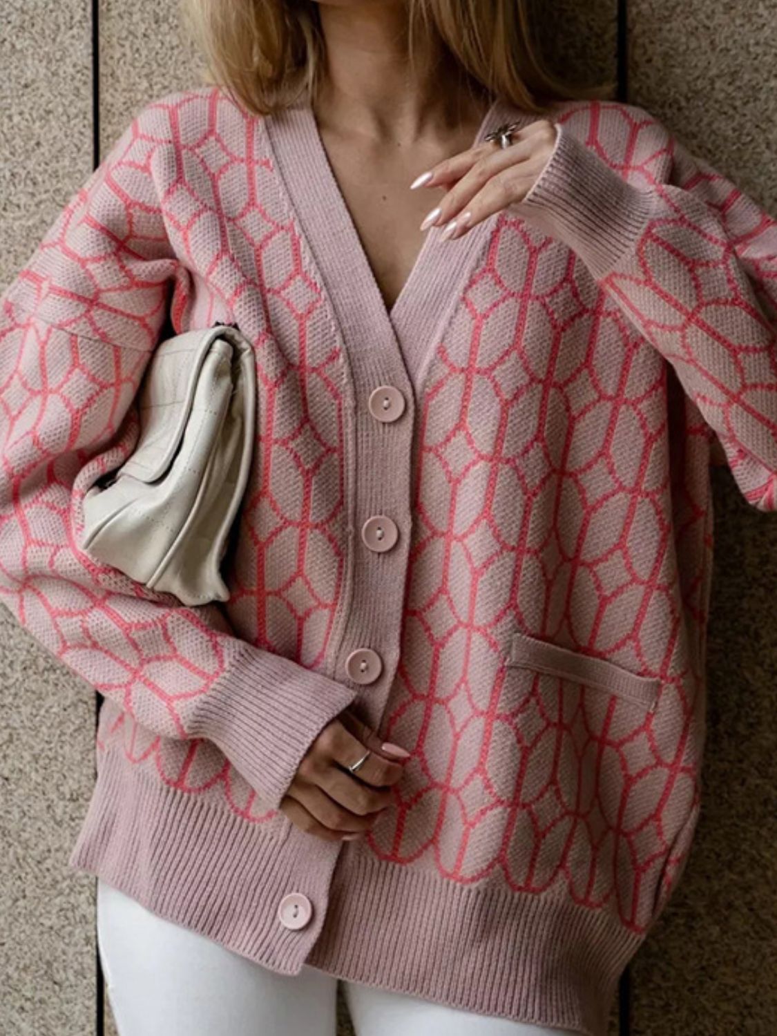 Dusty pink acrylic geometric knit button-up cardigan with V-neck and pockets.