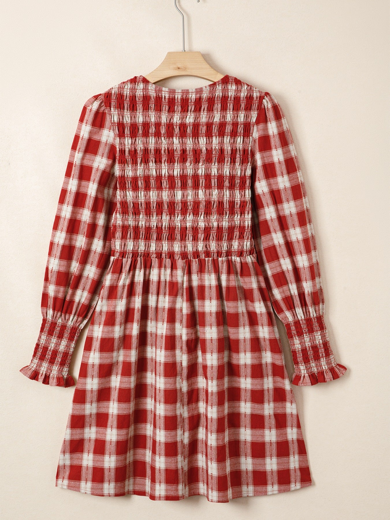 Red plaid cotton mini dress with smocked bodice, puff sleeves, and ruffled cuffs.