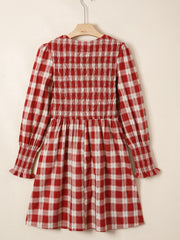 Red plaid cotton mini dress with smocked bodice, puff sleeves, and ruffled cuffs.