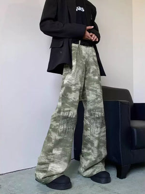 Abstract print wide-leg jeans in green and white camouflage with black embroidered detail.