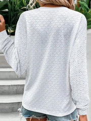 White lace-effect henley blouse with decorative buttons on sleeve detail.