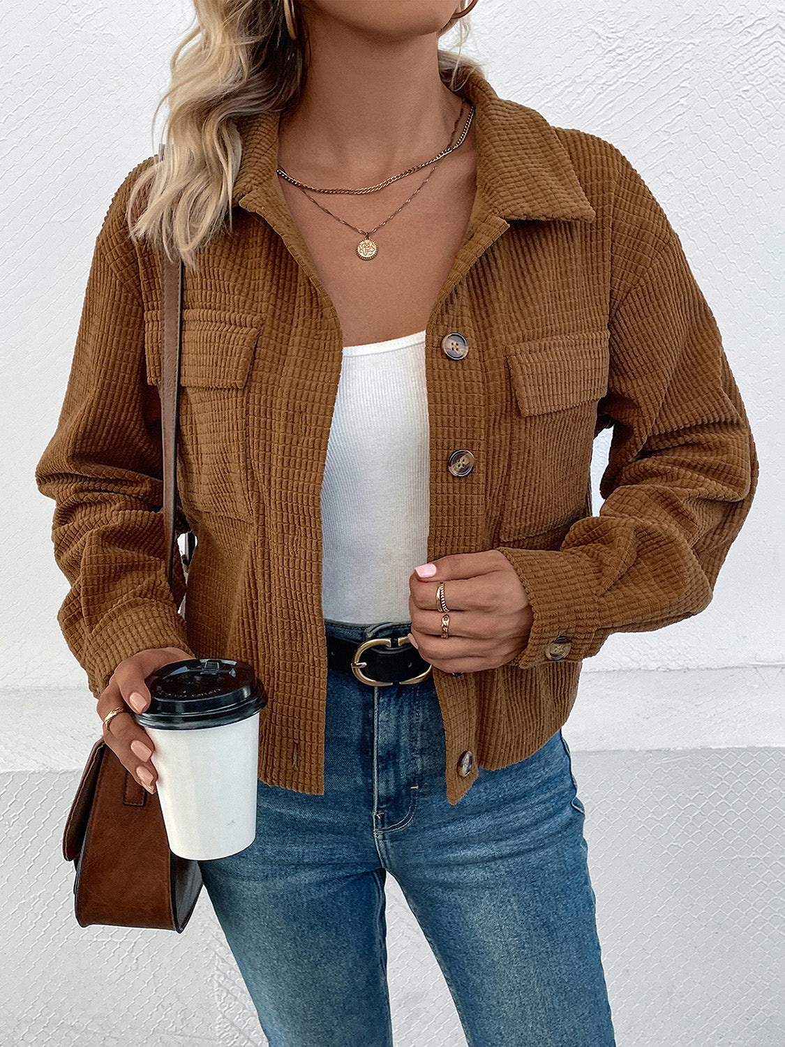 Textured corduroy cropped shirt jacket in camel with button front and chest pockets.