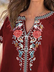 Burgundy blouse with floral embroidery and notched neckline.