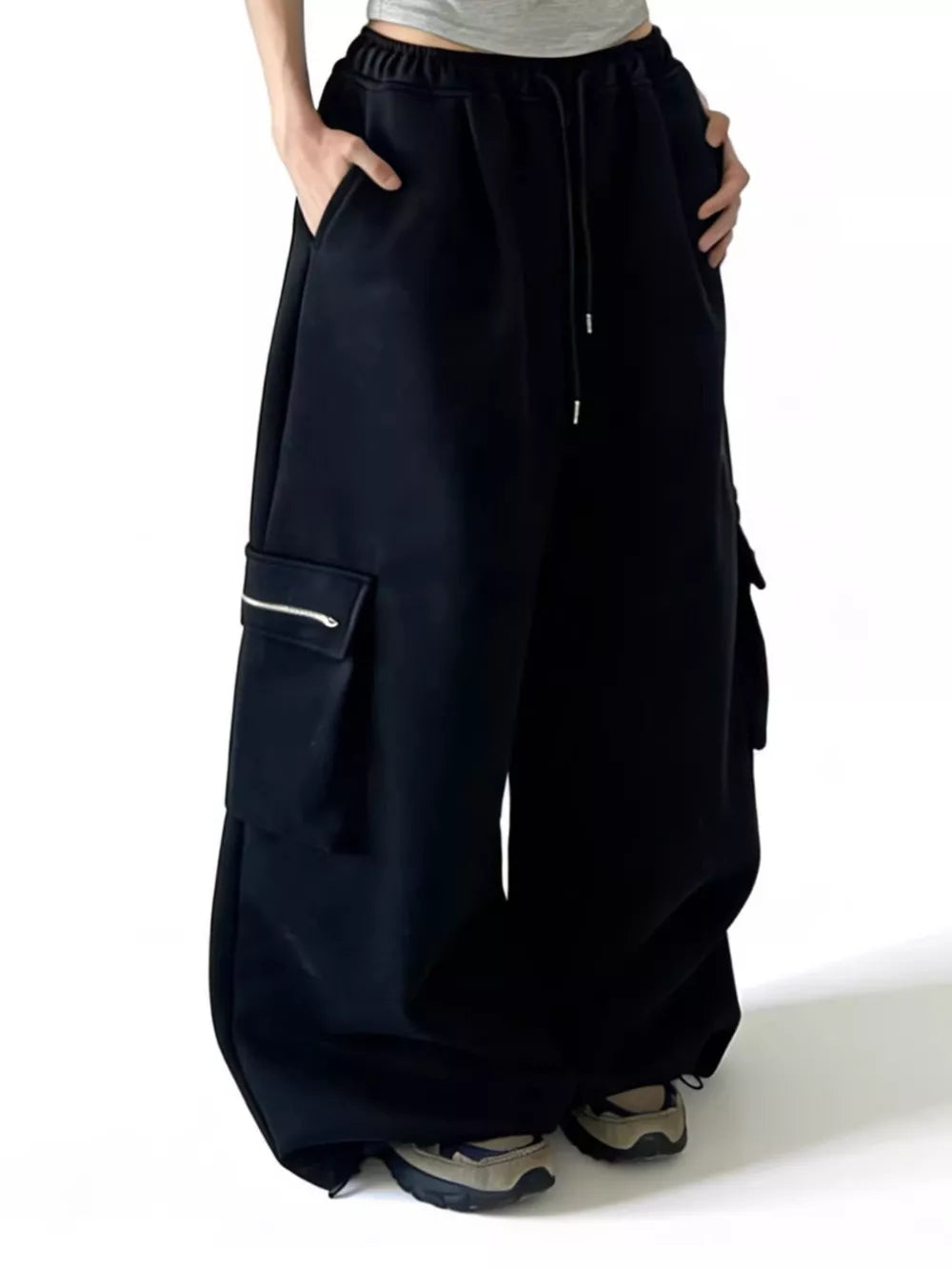 Black cotton cargo sweatpants with drawstring and zippered pocket detail.