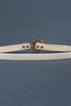 Ivory elastic waist belt with a circular disc detail and gold-tone buckle.