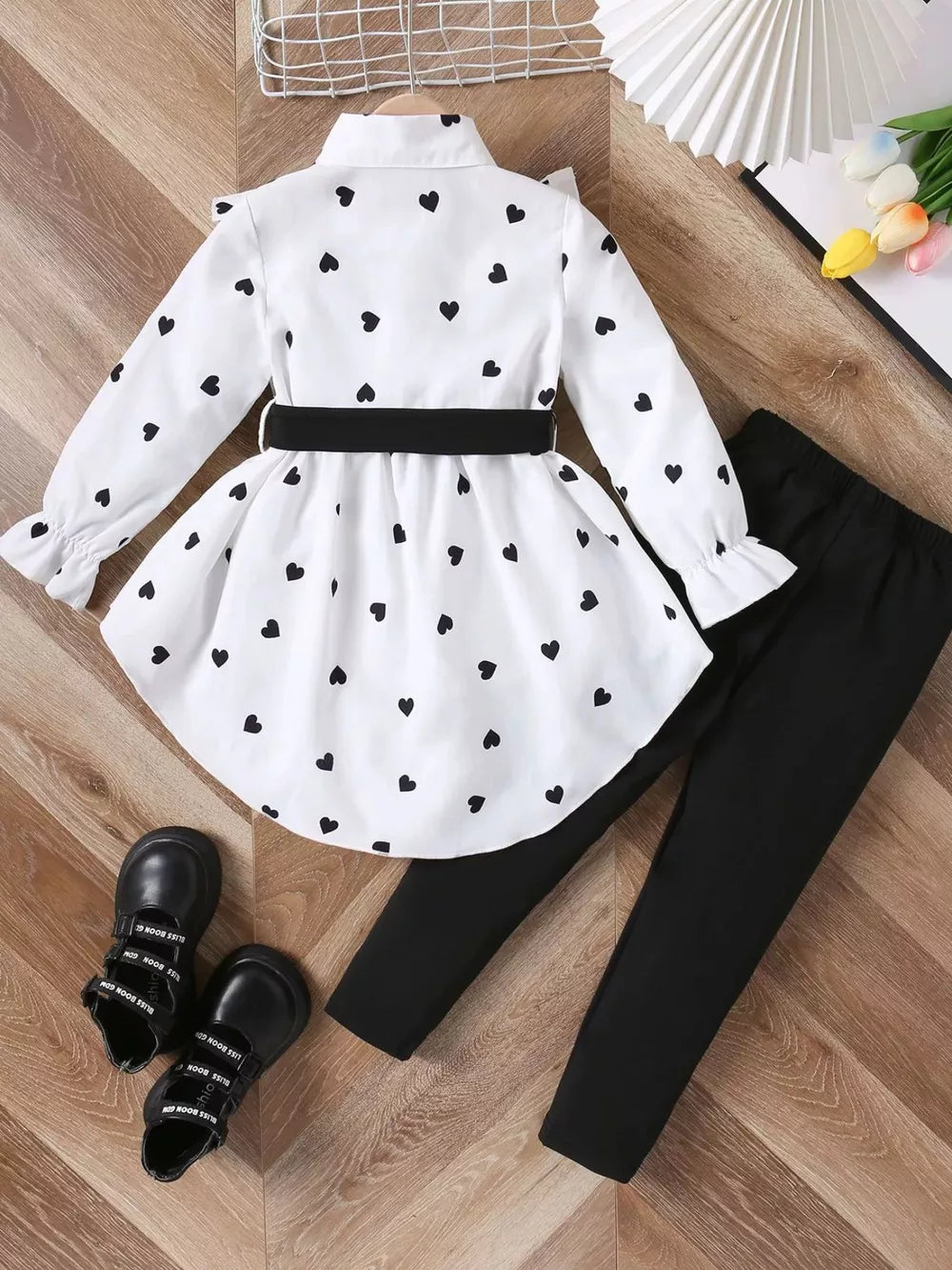 White heart print toddler outfit with black leggings and bow detail.