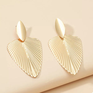 Gold leaf silhouette dangle earrings with textured surface