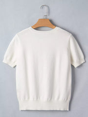 White short-sleeve sweater with crew neck and ribbed hem, made of cotton blend.